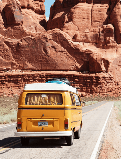 Travel destination - yellow vintage van in front of red rock formations